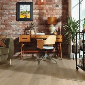 Sorrento oak flooring installed in contemporary home office with wooden desk and brick wall