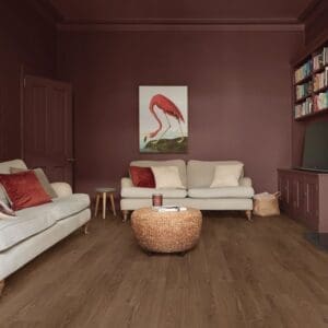 Roma oak pvp405 flooring installed in living room with burgundy walls and cream sofas