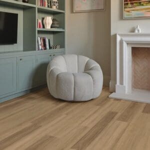 Belluno ash flooring installed in modern living room with white chair and fireplace