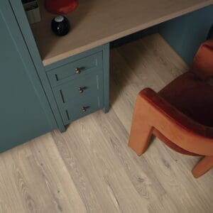 Close up of ravenna oak flooring with teal cabinetry and orange chair