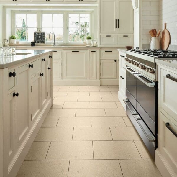 Ischia limestone pvt703 installed in kitchen with cream cabinets and stainless steel appliances