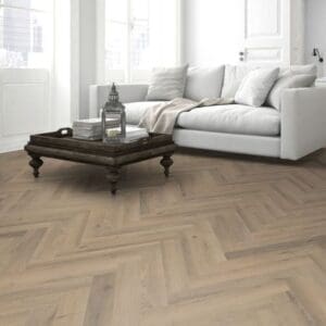 Living room with white sofa and greige oak herringbone laminate flooring