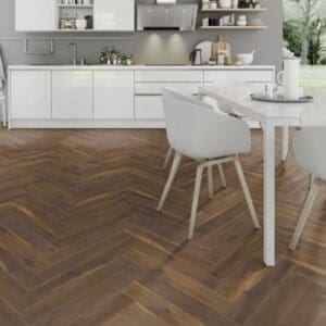 White dining area with coffee oak herringbone laminate flooring and modern chairs