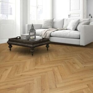 Cozy living space with blue sofa and oak herringbone flooring with ceramic stove