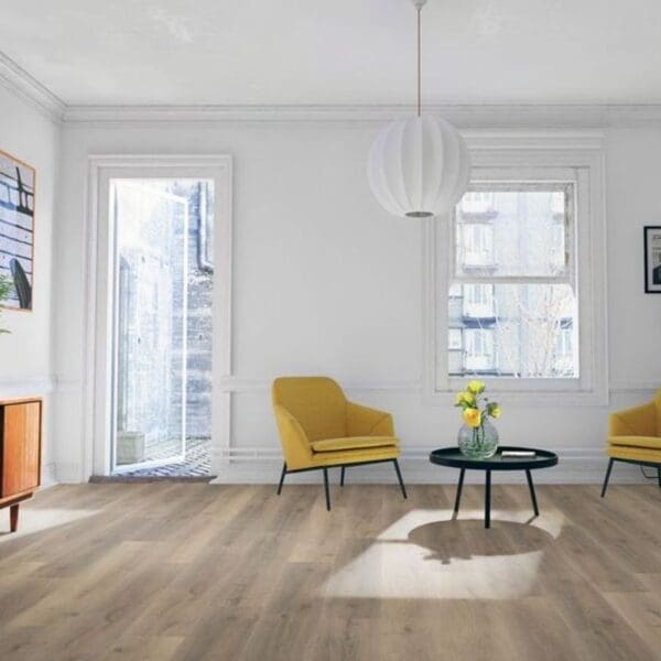 Greige oak laminate flooring in bright living room with yellow accent chairs