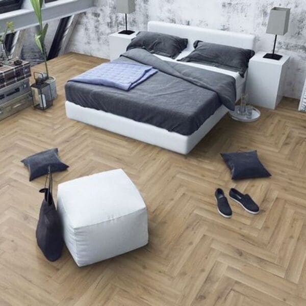Modern bedroom with white bed and ottoman on albany oak herringbone flooring