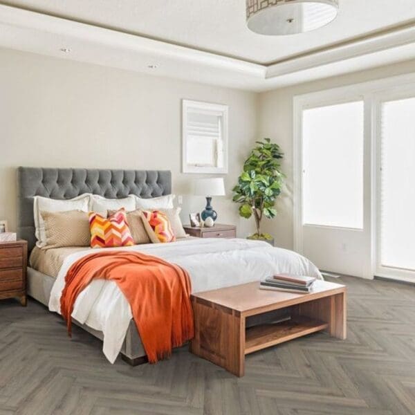 Bedroom with grey headboard and volcanic oak herringbone flooring