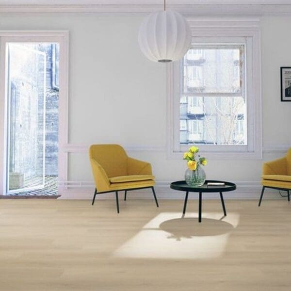 Light oak laminate flooring in bright living space with yellow accent chairs