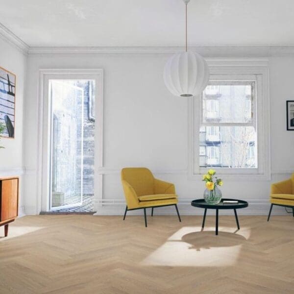Bright living room with yellow accent chairs and desert oak herringbone laminate flooring