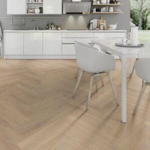 White kitchen with dining area featuring desert oak herringbone laminate flooring