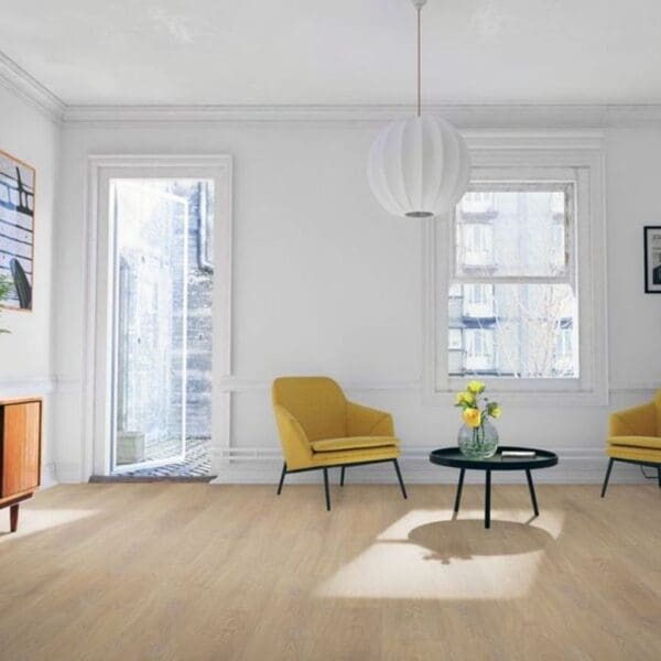 Desert oak laminate flooring in minimalist living room with yellow accent chairs