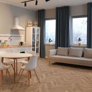 Open plan living space with lignum fusion premium robust fumed oak herringbone flooring and grey sofa