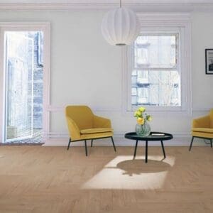 Lignum fusion premium oregon oak herringbone flooring in bright living room with yellow accent chairs