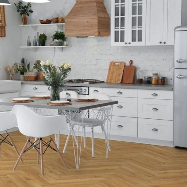 White kitchen with oak herringbone flooring and dining area with white chairs