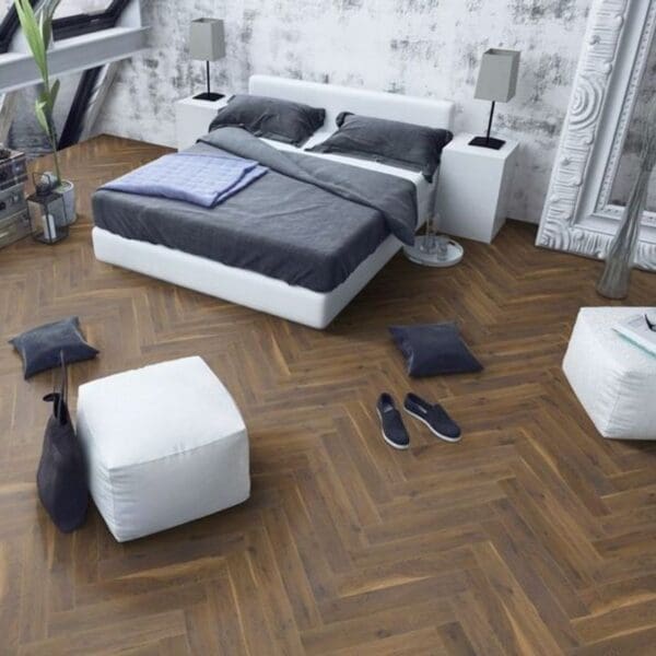 Contemporary bedroom with coffee oak herringbone laminate flooring and white furniture