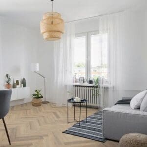 Bright living room with greige oak herringbone laminate flooring and modern furniture