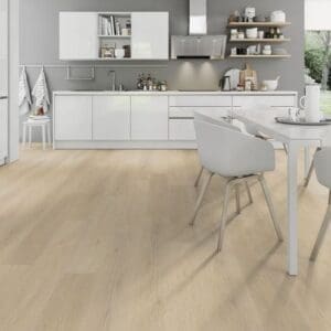 Light oak laminate flooring in contemporary white kitchen with dining area