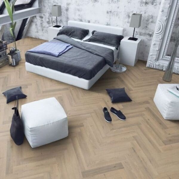 Contemporary bedroom with white bed and greige oak herringbone laminate flooring