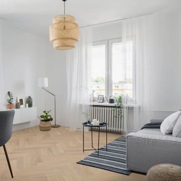 Modern living room with desert oak herringbone laminate flooring and minimalist furniture