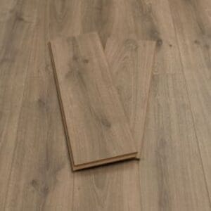 Pebble grey plank wood effect laminate flooring sample showing natural grain pattern