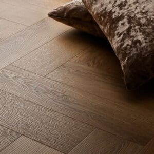 Textures traditional oak herringbone flooring with brown velvet cushion