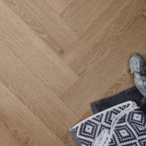 Textures light oak herringbone flooring with buddha statue and patterned rug