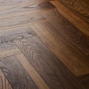 Close up view of textures warm walnut herringbone flooring showing detailed wood grain