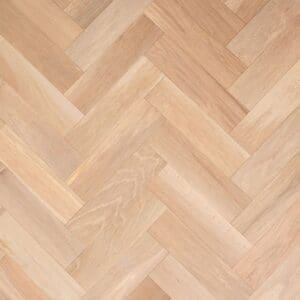A top-down view of Alderley Oak Herringbone engineered wood flooring showing the natural grain and geometric parquet pattern.