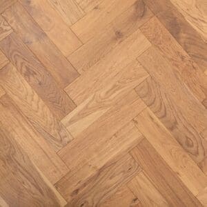 Smoked brushed lacquered oak herringbone engineered wood flooring sample showing geometric parquet pattern.