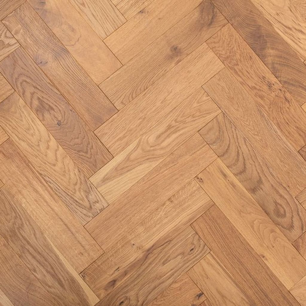 Smoked brushed lacquered oak herringbone engineered wood flooring sample showing geometric parquet pattern.