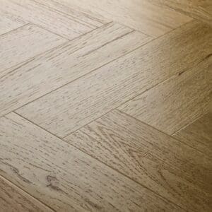 Close-up of Elements Inspirations Classic Oak Herringbone EIH09 luxury vinyl flooring showing the herringbone pattern.