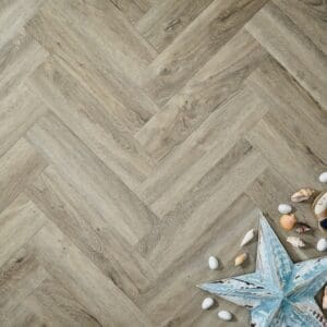 Elements Inspirations Dove Oak Herringbone EIH04 luxury vinyl flooring with beach-themed decorations.