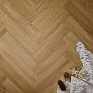 Elements Inspirations Golden Oak Herringbone EIH12 luxury vinyl flooring styled with blanket and decor.