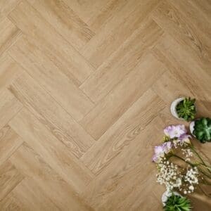 Elements Inspirations Sandy Oak Herringbone EIH01 luxury vinyl flooring with flowers and succulents.