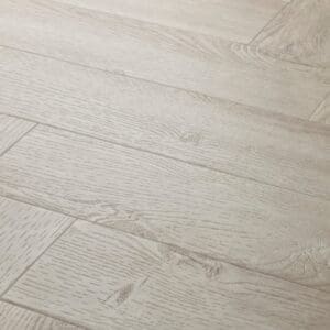 Close up of Elements Inspirations White Ash Herringbone EIH11 luxury vinyl flooring showing wood grain detail.
