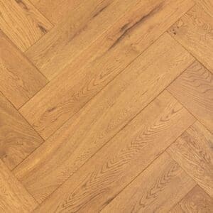 Close up of Farndon Oak Herringbone engineered wood flooring showing golden tones and brushed grain texture