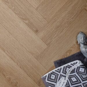 Textures Light Oak Herringbone TH10 luxury vinyl flooring with Buddha statue and towels