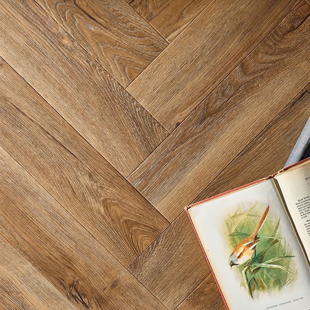 Textures LVT Distressed Oak Herringbone TH06 flooring with a book on top.