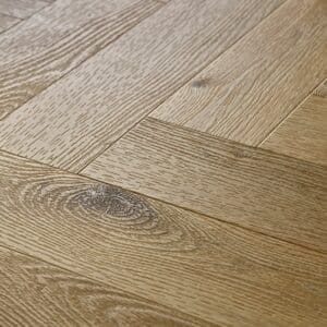 Close up of Textures LVT Sycamore Herringbone TH01 luxury vinyl flooring showing wood grain detail.