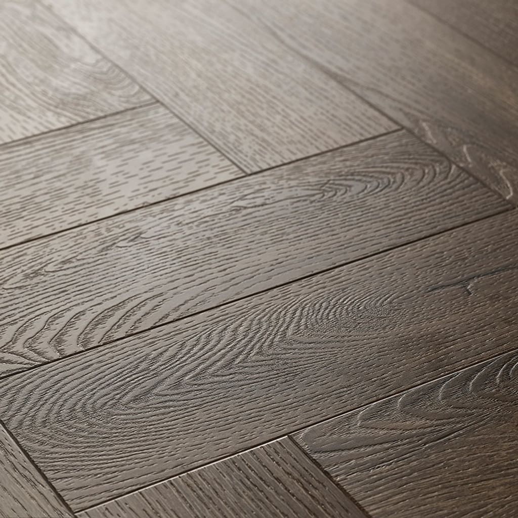 Close up of Textures LVT Tudor Oak Herringbone TH03 luxury vinyl flooring showing wood grain detail.