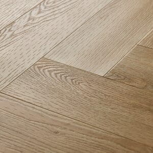 Close up of Textures LVT Washed Oak Herringbone TH04 luxury vinyl flooring showing the texture and herringbone pattern.