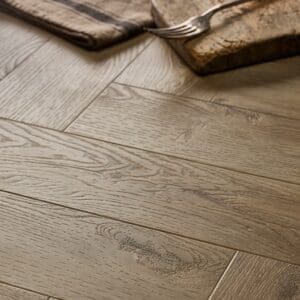 Textures LVT Weathered Oak Herringbone TH05 flooring close-up showing wood grain and herringbone pattern.