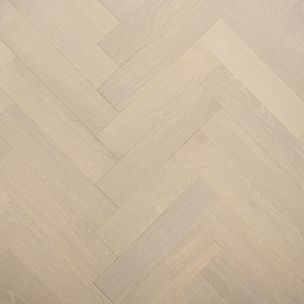 A top down view of grey brushed lacquered oak herringbone engineered wood flooring showing the parquet pattern.