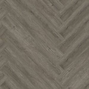 A top down view of Manor Oak Natural Dark Herringbone luxury vinyl flooring sample showing the wood grain pattern.
