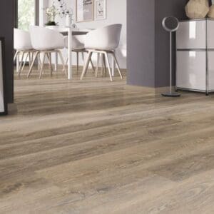 A bright dining area showcasing the natural wood effect of the Authentic Oak Natural vinyl planks.