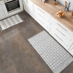 Kitchen area with Oxyde Rust stone effect flooring and white cabinetry