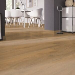 Tyrol Oak Honey flooring installed in a bright dining area with white chairs and grey walls.