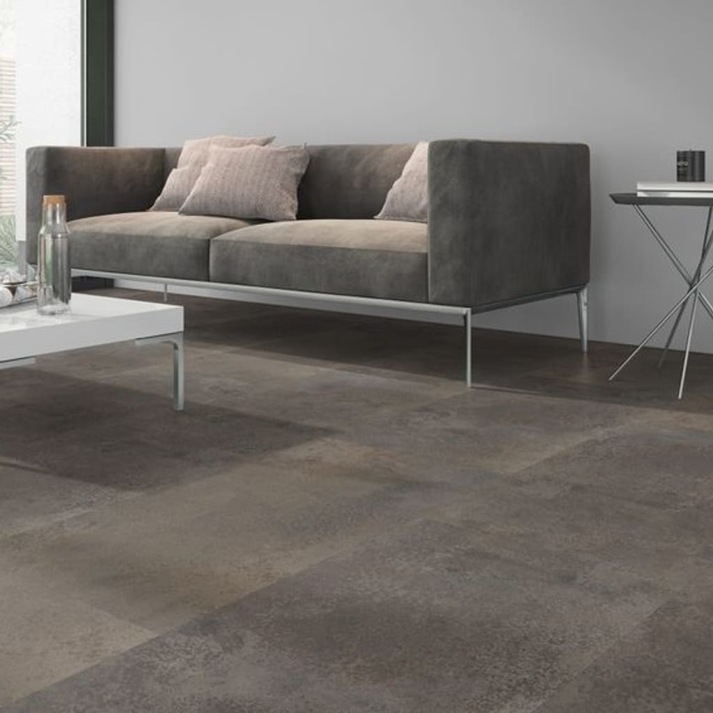 Close up of Oxyde Brown flooring in a lounge setting next to a grey sofa