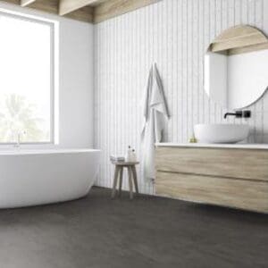 Origin Concrete Dark Grey flooring installed in a modern white bathroom with freestanding tub