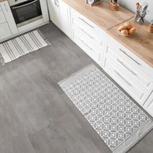 Kitchen area with grey stone effect vinyl flooring and white cabinetry